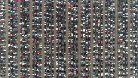 Aerial top down view of automaker car lot showing vehicles parked close to each other ready for further distribution the automotive industry is one of worlds most important economic sectors by revenue