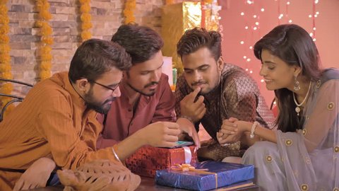A group of friends using smartphone in traditional cloths smiling and talking. Young people shopping online together on a mobile phone and also checking a new application during Diwali festival.