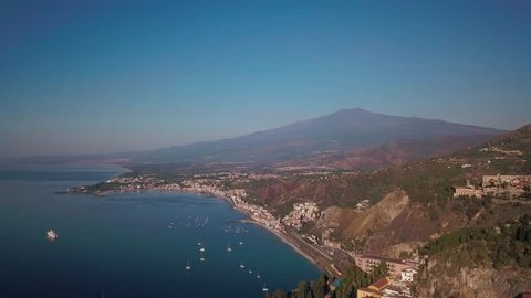 Taormina in Sicily with the mount Etna. Blue sea sunrise. Aerial view in 4K