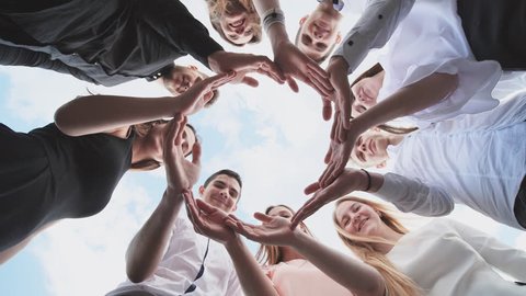 A group of high school students look through the shape of a circle created from their palms. The concept of friendly friends.