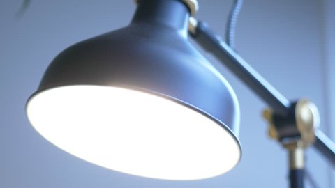 Desk lamp with LED light bulb being turned On and then Off. Closeup