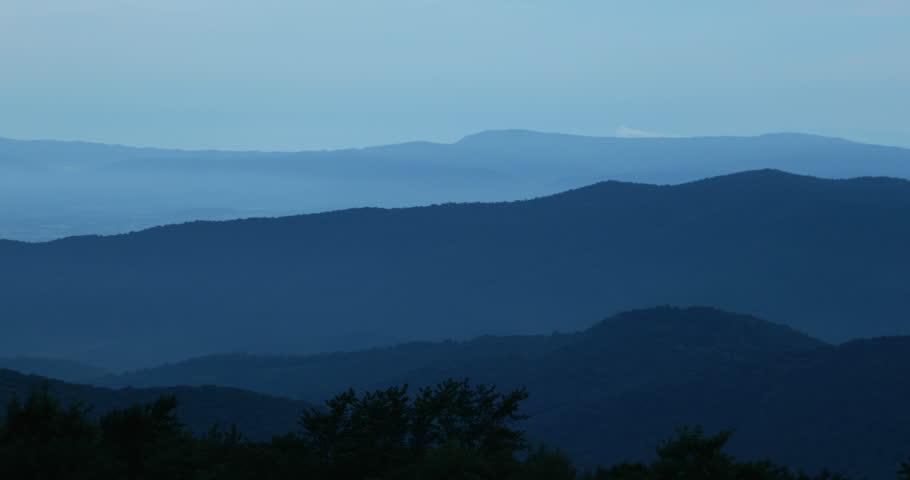 Blue Ridge Mountains at twilight with a tree silhouetted against the misty blue mountains