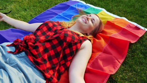 Ginger Girl Waving Rainbow Flag. The gay pride rainbow flag. LGBT Symbol of same sex relationship, equal rights.