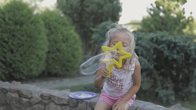 little girl blowing soap bubbles in summer park. fullhd slow motion video shooting by handheld gimbal