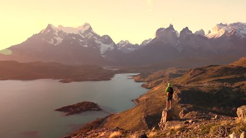 Man hiking and standing on a rock in Torres del Paine, Chilean Patagonia