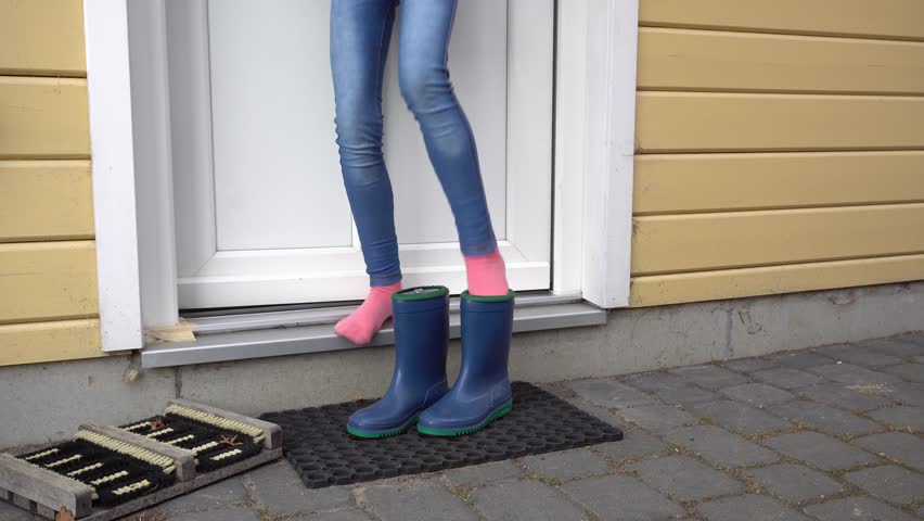Child comes out of the house and gets into blue rubber boots and walk away | Shutterstock HD Video #1015285813