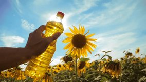 farmer holding a plastic bottle of sunflower oil in his hand field sunlight. slow motion video. blue sky background agriculture concept sunflower oil bottle farming sunset lifestyle field. man farmer