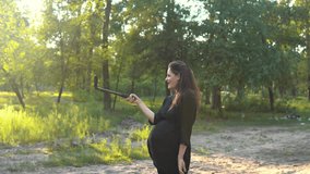 Young pregnant woman is shooting for a pregnancy blog
