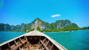 UltraHD video - Cruising towards the limestone cliffs overlooking a tropical island. on a handmade wooden boat with an improvised engine.