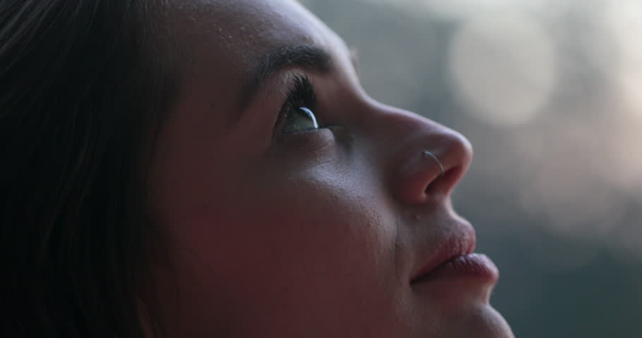 Young woman face opening and closing eyes. Girl meditating and in contemplation looking up to the sky with hope and faith Royalty-Free Stock Footage #1015309978
