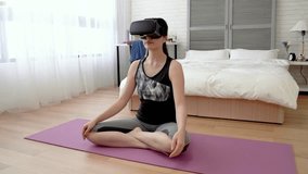 Asian woman wearing VR headset and follow the videos instruction doing the meditation step by step on the floor.