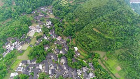 Aerial view, green rice and vegetable fields in poor village in China, Asia. Terraced rice  & field farm in the mountain & rural village with workers. Traditional agriculture & sustainable development