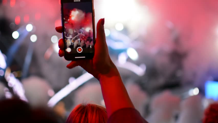 Taking a photo with mobile phone iPhone during rock band music performance concert on stage | Shutterstock HD Video #1015324228