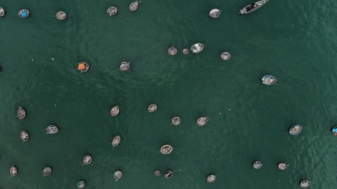 Aerial cinematic drone footage of hundreds of local fishing boats parked in the ocean in Da Nang in Vietnam. 