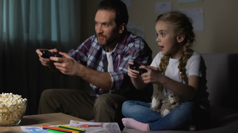 Playing video game father and daughter hugging after winning round, gadget hobby