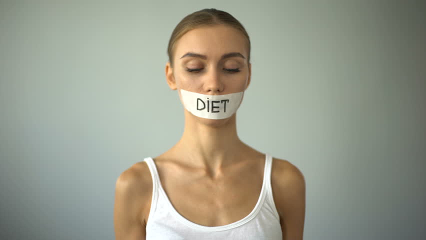 Thin girl with taped mouth holding plate with tomato, exhausting diet, anorexia Royalty-Free Stock Footage #1015350649