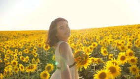 Dad and daughter walking along the field with sunflowers at sunset holding hands First-person view. Slow motion video. follow me. little girl and boy teenager run by the hand over the field lifestyle