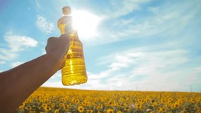 slow motion video. Man farmer hand hold bottle of sunflower oil the field at sunset. . man farmer agriculture plastic bottle oil sunflower concept. man shows lifestyle on the production of sunflower