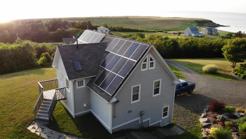 An aerial shot of a beautiful cottage home on the coast in cape breton nova scotia with solar panels | Shutterstock HD Video #1015355122