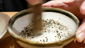 Motion of woman mashing sesame out inside bowl at Japanese restaurant with 4k resolution