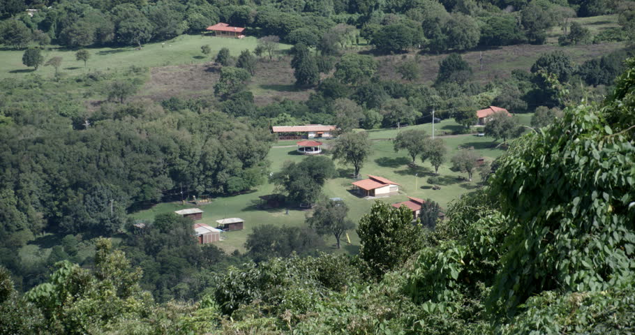 Distant look of a ranch hidden between mountains