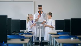 Digital class with two teens and a research worker with a tablet computer - Powered by Shutterstock - Get 15% off with code: PIKWIZARD15