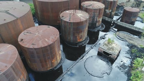 Tilted drone shot of leaking oil storage tanks on former industrial site in Ostrava, heavy pollution and ground contamination in Czech Republic, European Union
