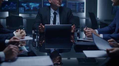 Senior Government Official Holds an Emergency Meeting with His Team of Advisors. Director Gives Orders to His Subordinates. In the Background Monitors with Various Data. Shot on RED EPIC-W 8K Camera.