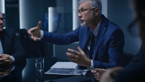 Portrait of the Corporate Businessman having Heated Debate with His Business Partners During Weekly Meeting. Serious Business People. Shot on RED EPIC-W 8K Helium Cinema Camera.