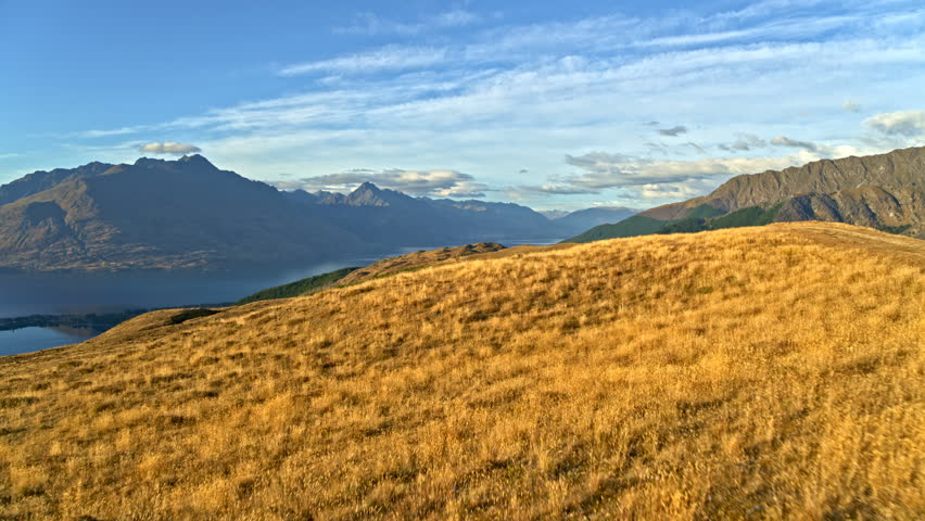 Aerial drone of clean wilderness mountains and cloudy blue sky of The Remarkables Mount Aspiring National Park New Zealand