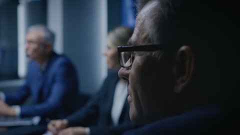 Portrait of the Senior Member of the Board Of the Directors Listening to His Business Partners on a Meeting. Shot on RED EPIC-W 8K Helium Cinema Camera.