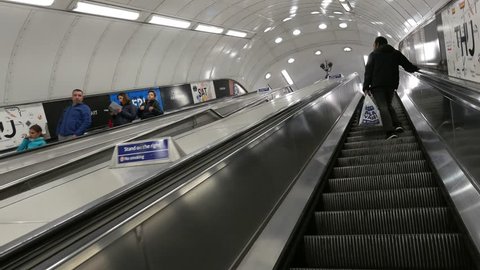 LONDON - JUNE, 2018: Commuters on escalators inside tube station. The Underground system serves 270 stations and has 402 kilometres (250 mi) of track, 45 per cent of which is underground.