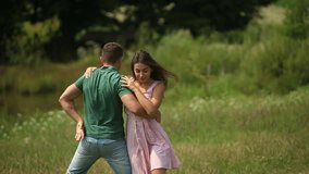 Beautiful couple dance in the field. the enjoy each other and smile. Summer weather. Romantic atmophere. slow motion