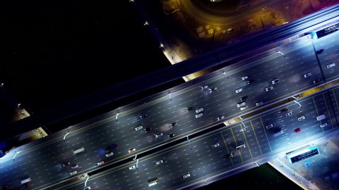 Aerial illuminated night overhead view city highway commuter vehicle traffic metro rail commercial area modern vehicle transport system UAE Middle East Dubai RED WEAPON