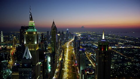 Aerial night illuminated city view Sheikh Zayed road commercial condominium district vehicle transport highway metro rail UAE Middle East Dubai RED WEAPON