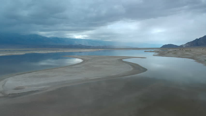 Aerial shot of Sierra Nevada mountains in stormy weather reflected on lake in California USA