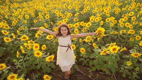 Happy little girl on the field of sunflowers in summer. beautiful little girl in sunflowers. slow motion video. lifestyle girl teenager and sunflowers field concept agriculture