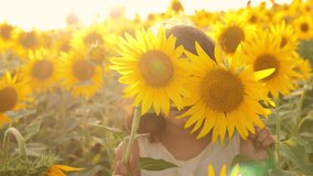 Happy portrait little girl on the field of sunflowers in summer. beautiful portrait little girl in sunflowers. slow motion video. lifestyle girl teenager and sunflowers field concept agriculture