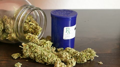 SLIDE LEFT Marijuana buds in glass Rx jar for recreational or prescription medicinal weed smoking.