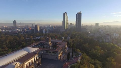 Flying over El Castillo de Chapultepec while approaching the tallest skyscrapers of Mexico City during the sunrise
