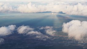 Plane soaring through cloud, aerial view of city and ocean slow motion video