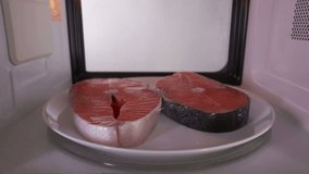 Using microwave oven to defrost salmon steaks before cooking it