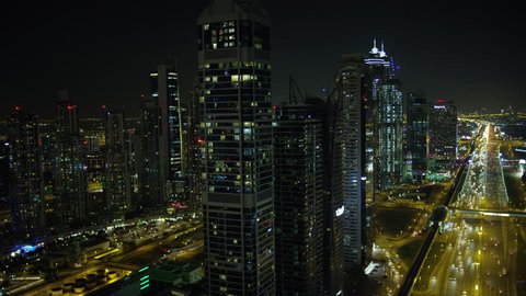 Dubai - March 2018: Aerial night illuminated city view Sheikh Zayed road skyline skyscrapers commercial condominiums vehicle transport highway metro UAE RED WEAPON
