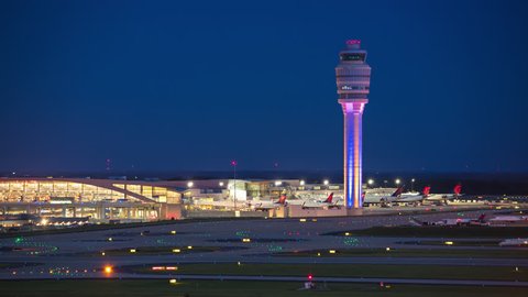 ATLANTA, GA - 2018: ATL Hartsfield Jackson International Airport Nightscape Timelapse featuring the Air Traffic Control Tower and Terminal Building Exterior with Streaking Lights from Airplanes