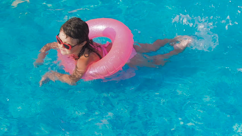 Child in the pool. A little girl is swimming in the pool. | Shutterstock HD Video #1015458535