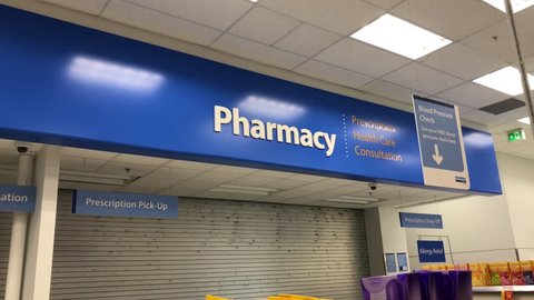 Coquitlam, BC, Canada - August 06, 2018 : Motion of pharmacy sign and blood pressure check sign inside Walmart store with 4k resolution