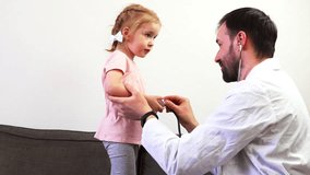 A father and his cute daughter playing in doctor.
