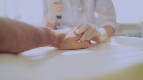 White young woman dermatologist checking hand skin of caucasian male patient