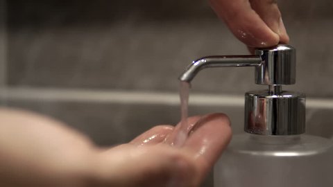 Hands using wash hand sanitizer gel pump dispenser, cinematic dof