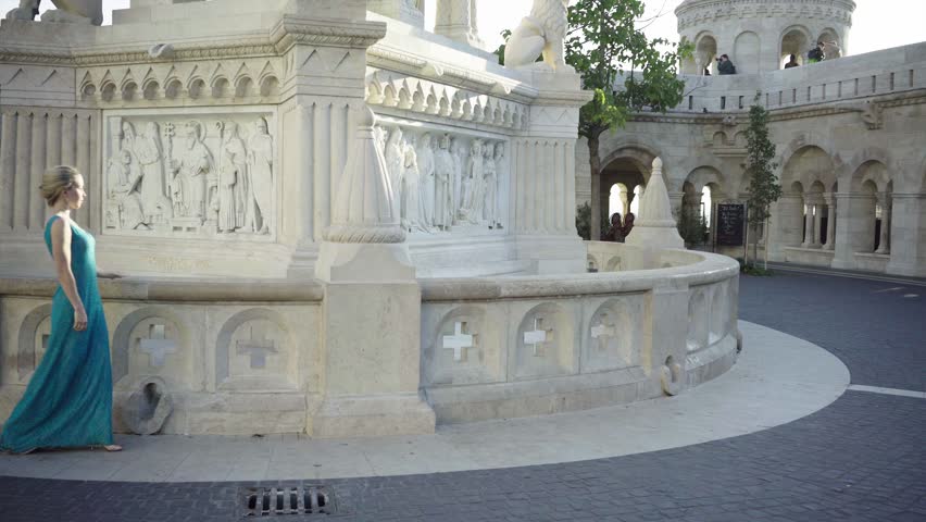 Beautiful woman walking near a monument in a castle in Budapest